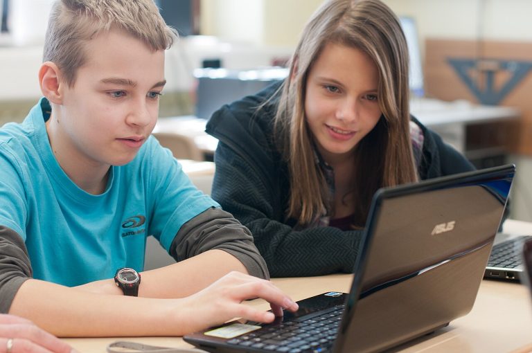 Two students learning together on a laptop through free online courses with certificates