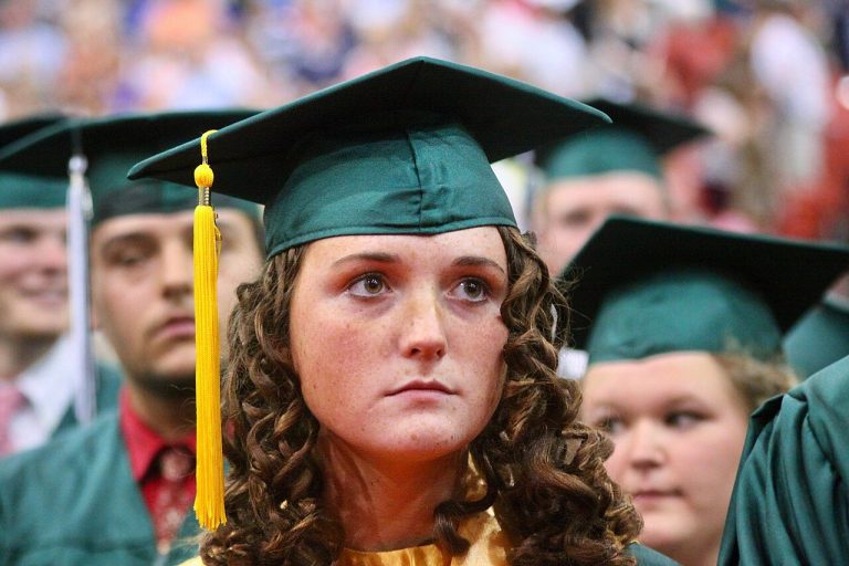 A graduate in cap and gown learning how to find scholarships