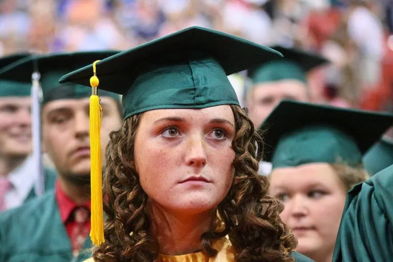 A graduate in cap and gown learning how to find scholarships