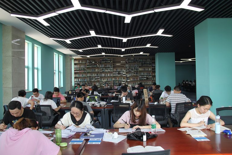 Students studying together in a library learning how to study effectively