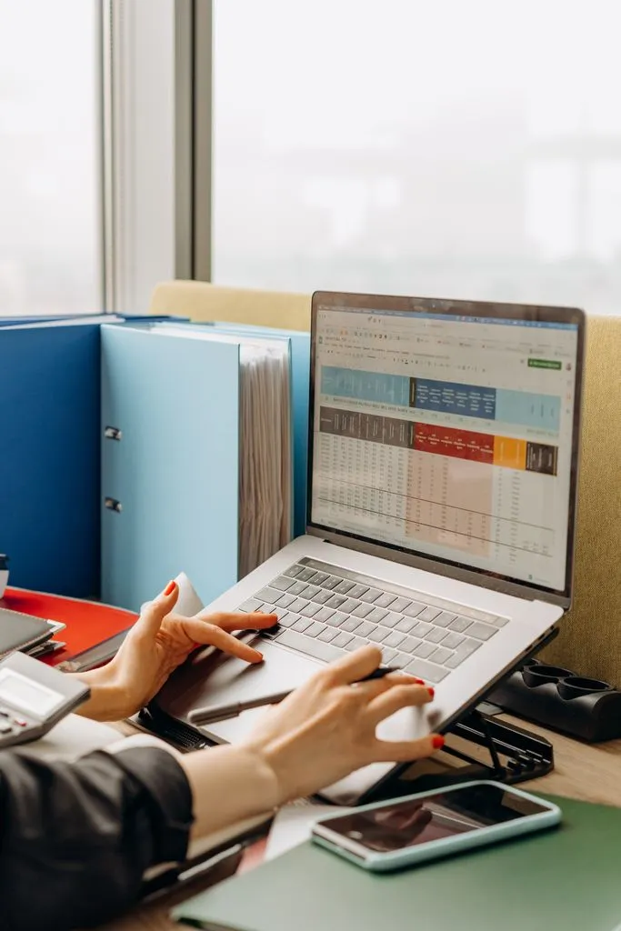 An office desk with folders and a laptop used for administrative work