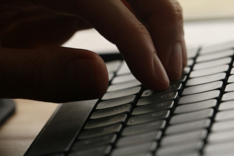 Close-up of hands typing fast on a keyboard while learning how to improve typing speed for data entry jobs