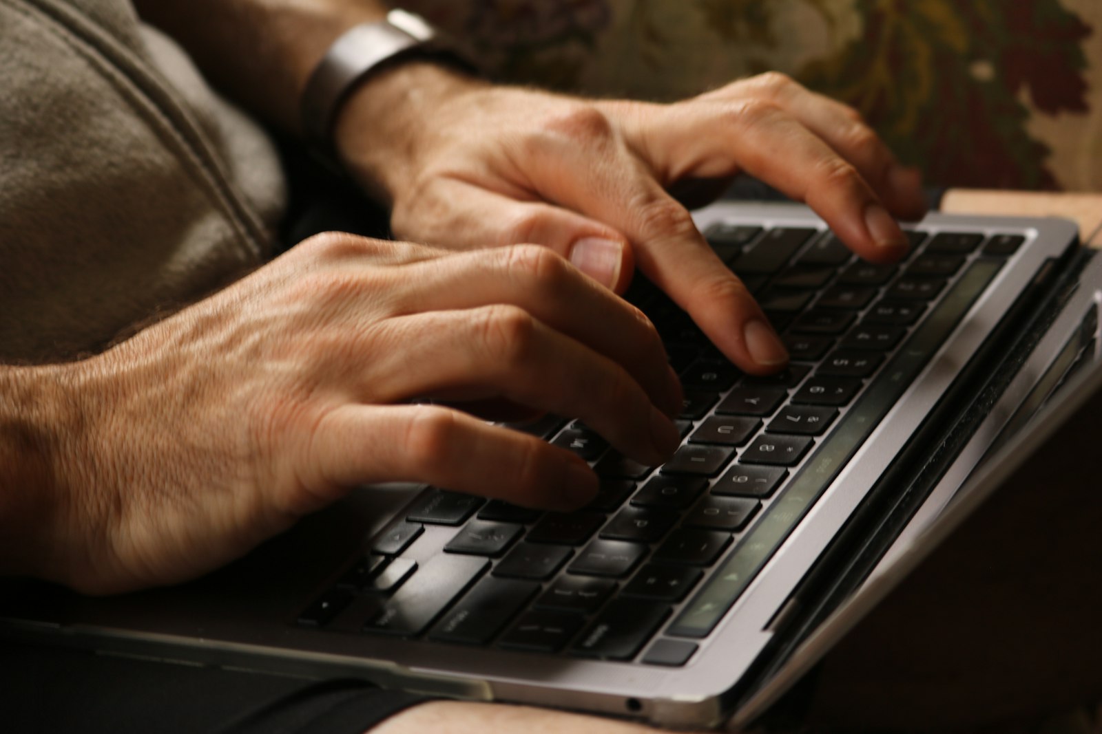 Hands practising touch typing on a laptop keyboard with fingers on the home row keys