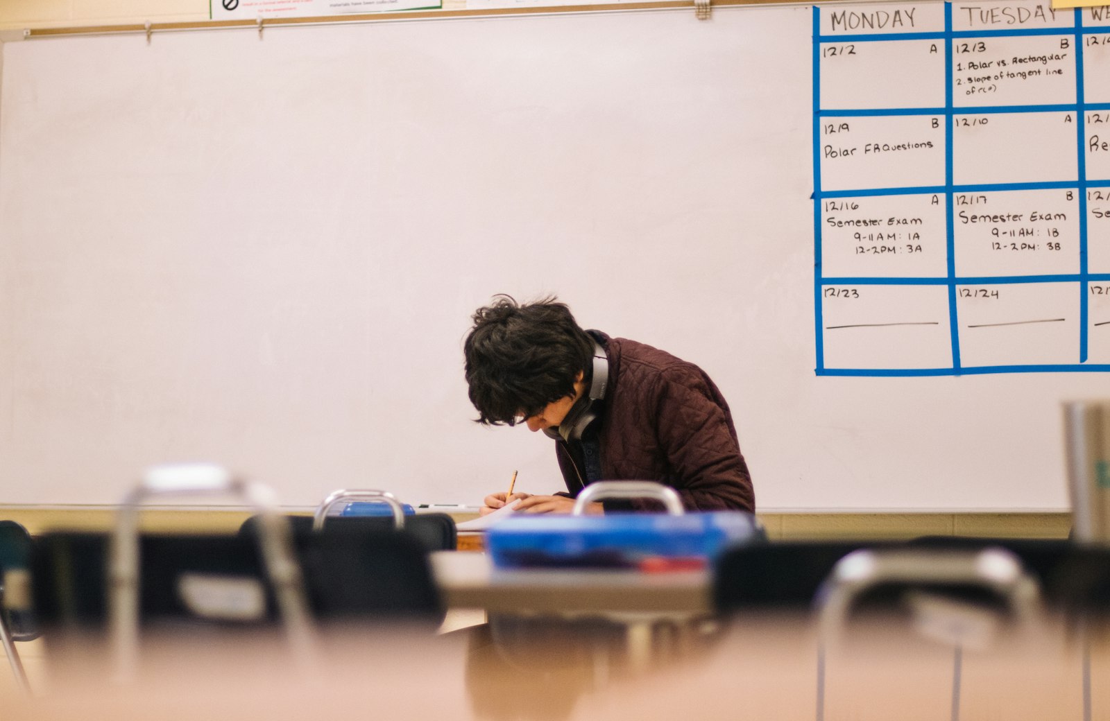Student writing on paper at a desk while learning how to study with flashcards